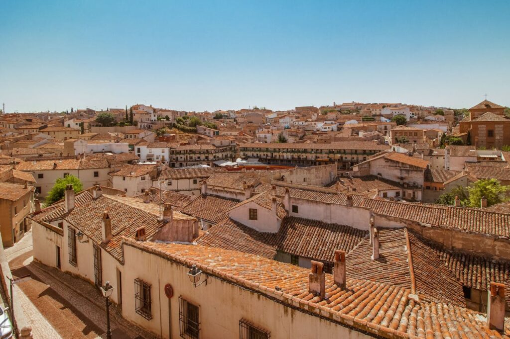 Discover the charming rooftop view of Chinchón, showcasing traditional Spanish architecture bathed in summer light.