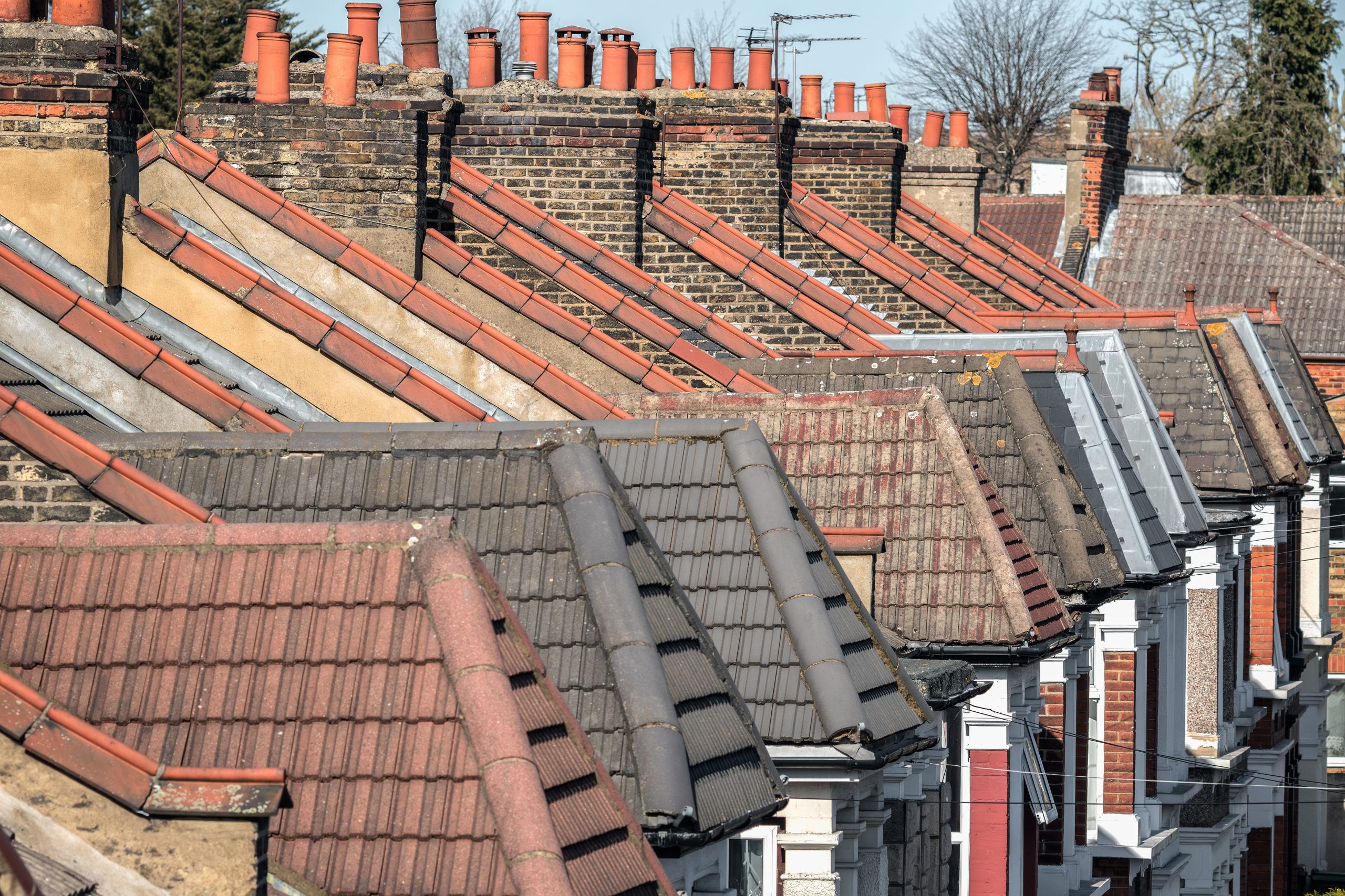 row,of,brick,chimneys,and,dormer,rooftop,in,victorian,terraced